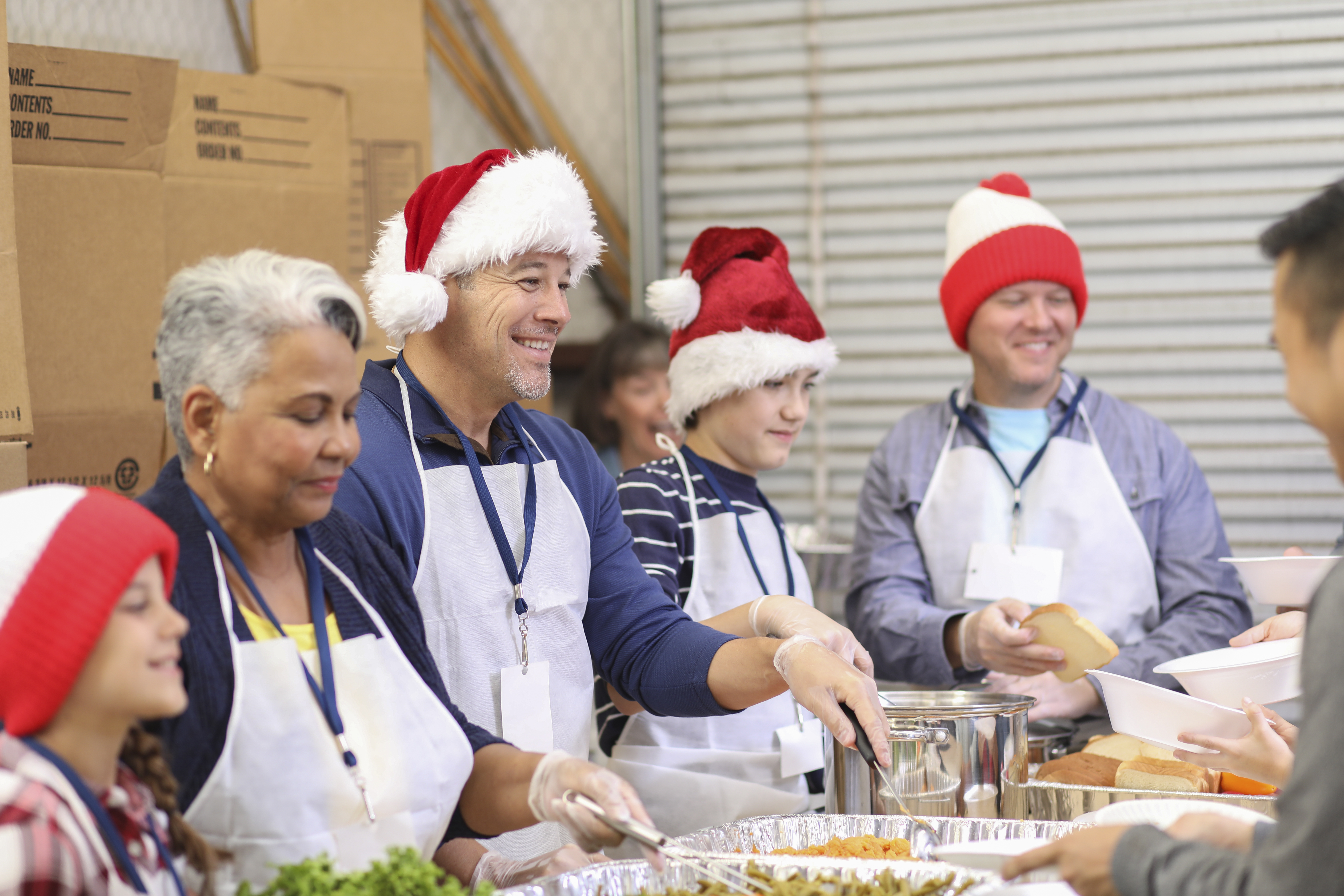 Multi-ethnic volunteers serves food at soup kitchen at Christmas.